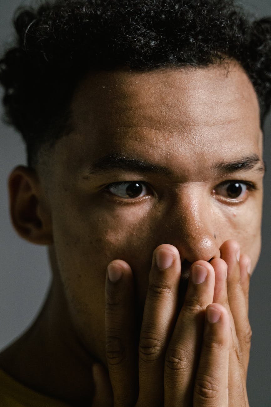 a fearful man covering his mouth